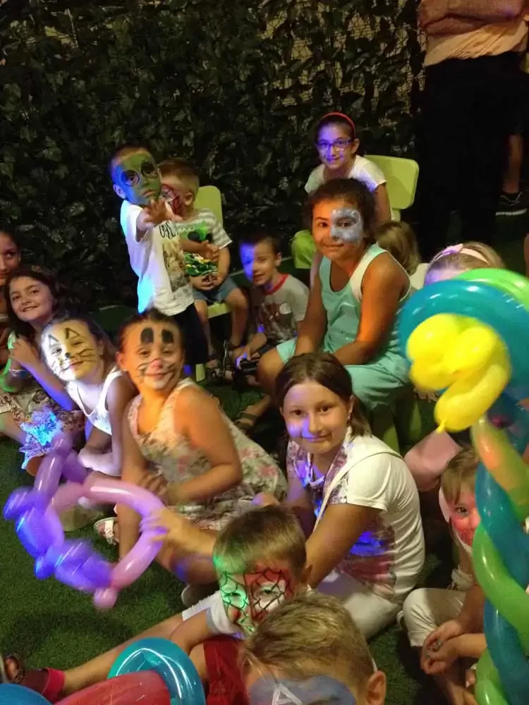 Kinder mit Gesichtsbemalung haben Spaß auf einer Party mit Ballons.